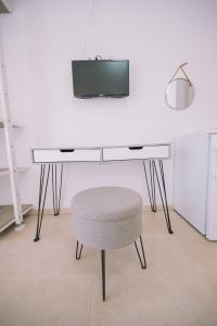 een bureau met een stoel en een tv aan de muur bij Apartments Leandra in Ulcinj