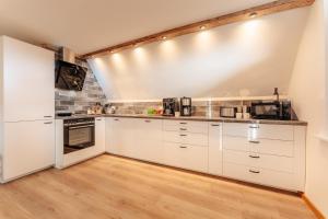 cocina con armarios blancos y suelo de madera en Harzlodge Lebenstraum, en Braunlage