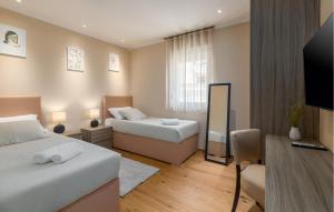 a hotel room with two beds and a television at Lovely Home In Barbariga With Wifi in Barbariga