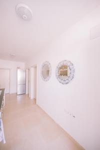 een witte kamer met twee spiegels aan de muur bij Apartments Leandra in Ulcinj