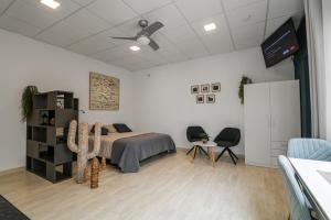 a bedroom with a bed and two chairs and a tv at Urban Rooms San Roque with Solarium in Las Palmas de Gran Canaria