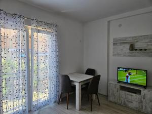 a dining room with a table and a television at Villa Stedar in Ohrid