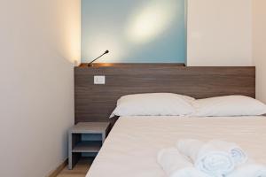 a bedroom with a bed with a wooden headboard at Hotel BluMarine in Roseto degli Abruzzi