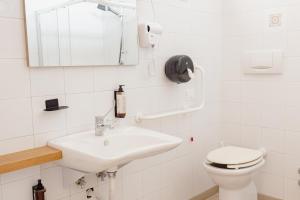 a white bathroom with a sink and a toilet at Hotel BluMarine in Roseto degli Abruzzi