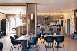 a restaurant with tables and chairs and a bar at Hotel BluMarine in Roseto degli Abruzzi