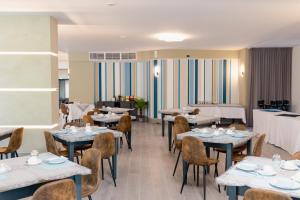 a dining room with tables and chairs and tablesktop at Hotel BluMarine in Roseto degli Abruzzi