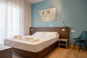a bedroom with a bed with two towels on it at Hotel BluMarine in Roseto degli Abruzzi