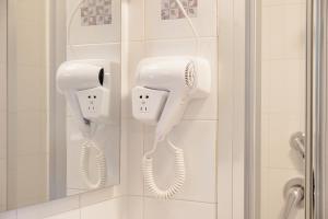 ロゼート・デッリ・アブルッツィにあるHotel BluMarineのバスルーム(壁に白いヘアドライヤー2台付)