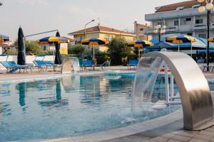 a swimming pool with a fountain in a hotel at Hotel BluMarine in Roseto degli Abruzzi