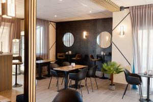 a restaurant with tables and chairs and mirrors at Hotel BluMarine in Roseto degli Abruzzi