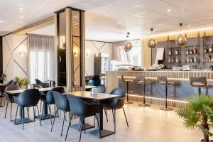 ロゼート・デッリ・アブルッツィにあるHotel BluMarineのテーブルと椅子とバーのあるレストラン