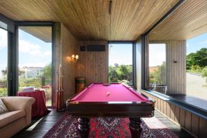 a pool table in a room with windows at Dream Guincho in Cascais
