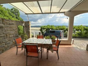 a table and chairs on a patio with a car parked at Rooms and Apartments Roza in Portorož