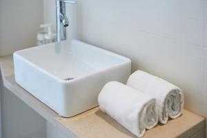 Un lavabo blanco y toallas en un estante en un baño. en Sintra Sweet Apartment I - Free Parking, en Sintra 23 fotos más
