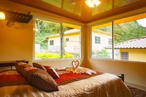 - une chambre avec un lit dans une pièce dotée de fenêtres dans l'établissement Hotel Central Boquete, à Boquete