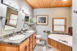 a bathroom with two sinks and a tub and a toilet at Riverfront Lake Lure Lodge with Deck on 13 Acres in Lake Lure +31 photos