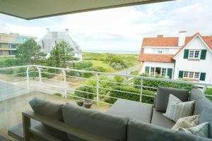 ein Wohnzimmer mit einem Sofa auf dem Balkon in der Unterkunft Huswell - Apartment with sea view & terrace in Oostduinkerke in Koksijde