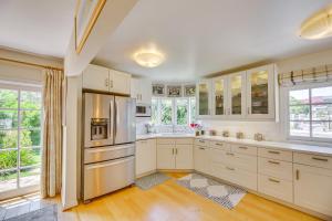 a kitchen with white cabinets and a stainless steel refrigerator at Vibrant Home with Patio - Near Santa Monica Pier! in Los Angeles
