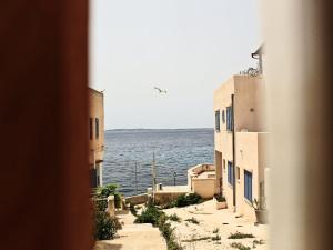 a view of the ocean from between two buildings at Fenici Levanzo - Island Apartments in Levanzo +41 photos
