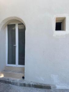 a white building with a door and a window at L'échappée belle in Le Pouget