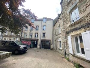 a car parked in a parking lot next to buildings at studio 3- les moulins in Cherbourg en Cotentin