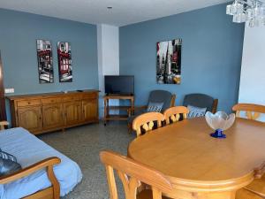a room with a table and chairs and a tv at Prado in Peniscola +2 photos