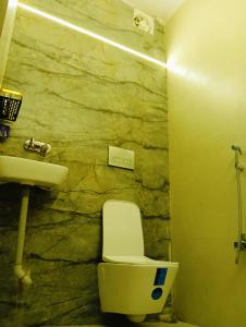 a bathroom with a white toilet and a sink at Malaiya Homestay - Grandeur Living Experience in Jabalpur