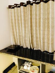 a curtain in a room with a table with dishes at Malaiya Homestay - Grandeur Living Experience in Jabalpur