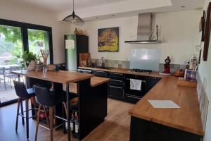 een keuken met een houten aanrecht en een keukeneiland bij Maison avec vue imprenable in Saint-Martin-de-Clelles