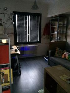 een woonkamer met een bank en een raam bij Maison avec vue imprenable in Saint-Martin-de-Clelles