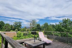 een roze stoel bovenop een houten terras bij Maison avec vue imprenable in Saint-Martin-de-Clelles +2 foto's