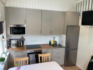 a kitchen with white cabinets and stainless steel appliances at Hultatorpet in Tvååker +5 photos