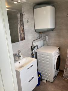 a bathroom with a sink and a washing machine at Hultatorpet in Tvååker