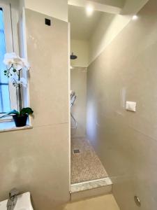 a bathroom with a shower with a toilet and a window at Happy Family Apartments Incantesimo in Genova