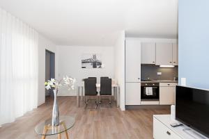 a living room with a vase of flowers on a table at Spreepolis Boardinghaus in Berlin +21 photos