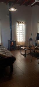 a living room with a fireplace and a couch and a table at El Bagual de Monte XL in San Miguel del Monte