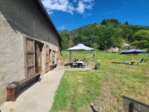 eine Terrasse mit einem Tisch und Sonnenschirmen neben einem Gebäude in der Unterkunft Calme et plein air in Monestier-de-Clermont + 7 Fotos
