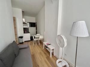 a living room with a couch and a floor fan at Joli T2 en plein centre-ville de Lyon in Lyon