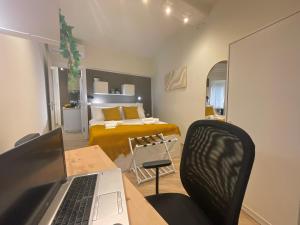 a room with a laptop on a table with a bed at Happy Family Apartments Incantesimo in Genova