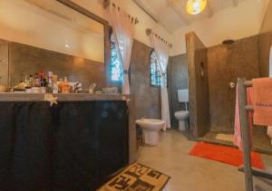 a bathroom with a shower and a toilet and a sink at villa zoe dhahabu BNB in Watamu +7 photos