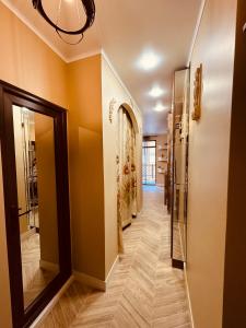 a hallway with orange walls and wooden floors and a mirror at Piacere in Gonio in Kvariati +12 photos