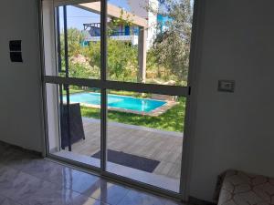 an open glass door with a view of a swimming pool at Dar Julia in Sousse