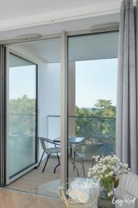 a room with a balcony with a table and chairs at Pinea 620 - Easy - Rent Apartments VI piętro z widokiem na morze in Pobierowo