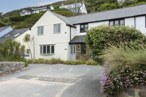 a white house with a driveway at Castaways in Porthtowan