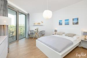 a white bedroom with a large bed and a table at Pinea 620 - Easy - Rent Apartments VI piętro z widokiem na morze in Pobierowo +33 photos