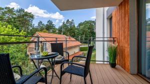 a patio with a table and chairs on a balcony at ENKLAWA Apartamenty Piamola in Krynica Morska
