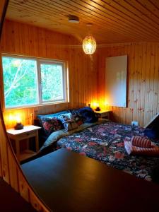 a bedroom with a bed in a wooden room at Caitríona's Cottages - Adult Only Pet Friendly - Hot Tub, Sauna, Pool - Sleeps 4 in Rossinver
