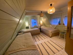 a bedroom with two beds and a room with windows at Leszczynowy domek nad jeziorem in Dobre Miasto