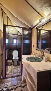 a bathroom with a sink and a toilet in it at Sahara Dunes Camp in Merzouga