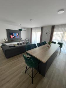 a living room with a table and a couch at Apartman 100JIĆ in Nova Gradiška